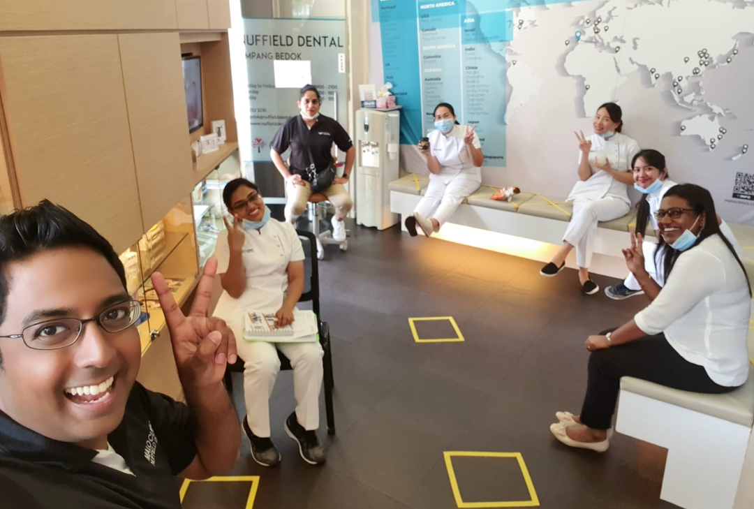 Friendly Nuffield Dental staff members smile and pose in the clinic's welcoming waiting area.
