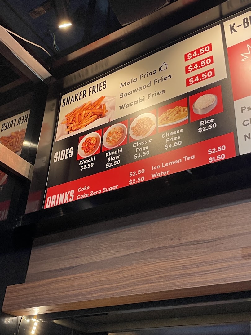 A digital menu board displaying various fries, sides, and drinks with their prices.