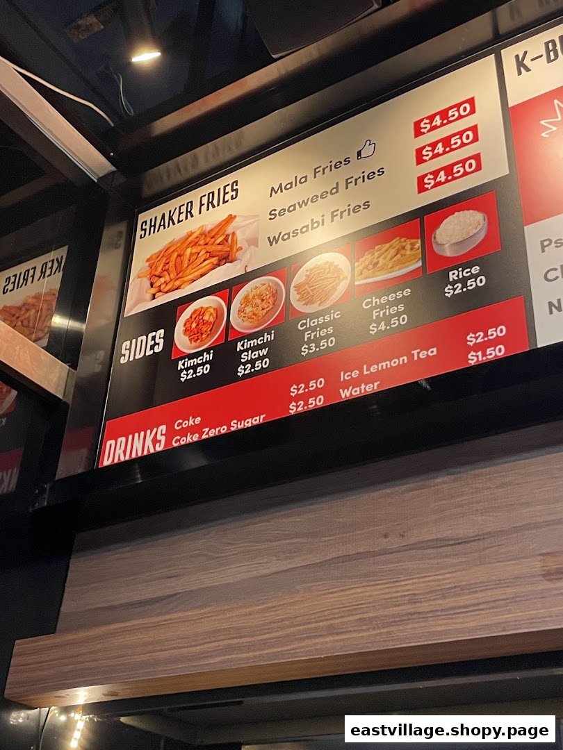 A digital menu board displaying various fries, sides, and drinks with their prices.