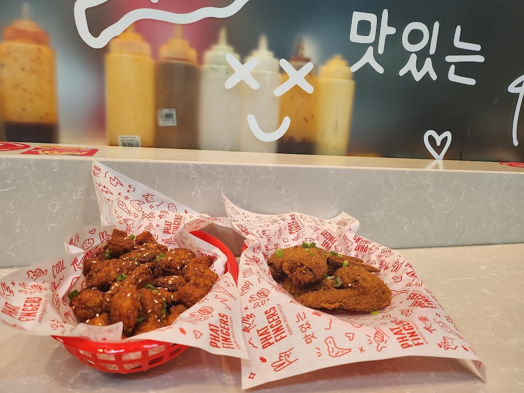 Two servings of delicious Korean fried chicken, one in a basket and one on paper, on a counter.