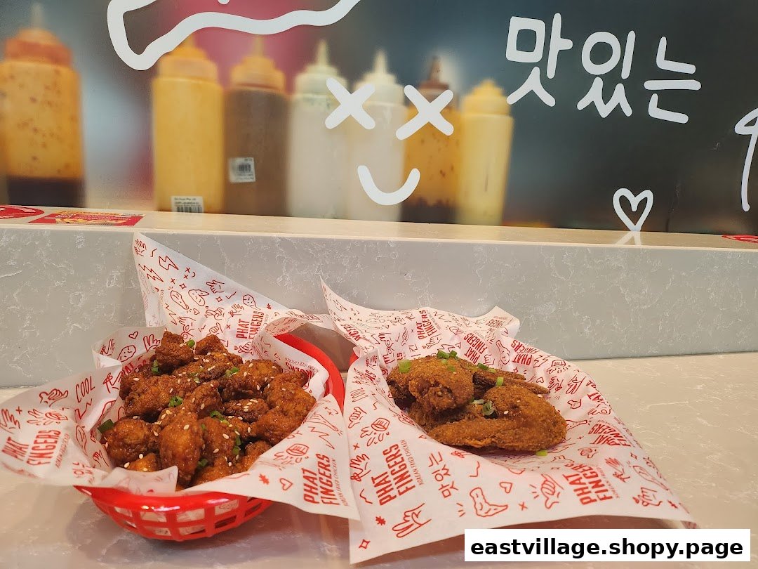 Two servings of delicious Korean fried chicken, one in a basket and one on paper, on a counter.
