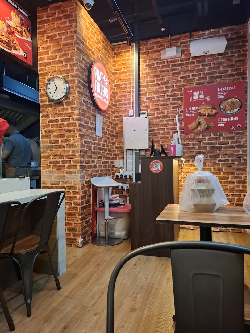 Interior view of Phat Fingers Korean Fried Chicken & Burgers, showing seating, brick walls, and menu boards.