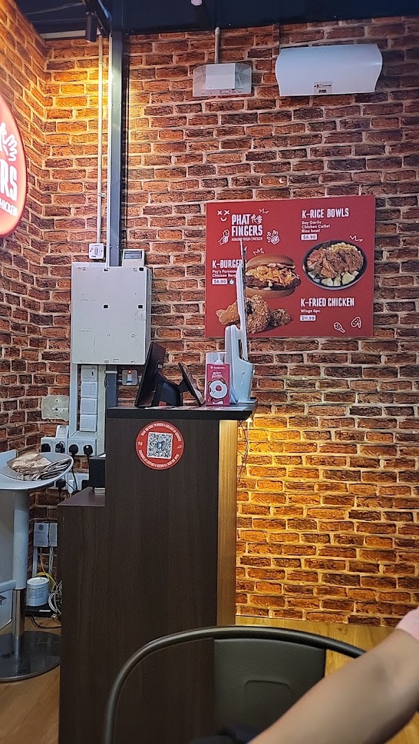 A menu board on a brick wall showcasing Korean fried chicken, burgers, and rice bowls.