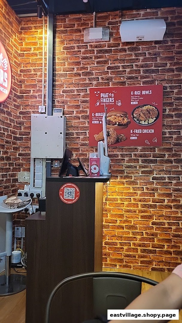 A menu board on a brick wall showcasing Korean fried chicken, burgers, and rice bowls.