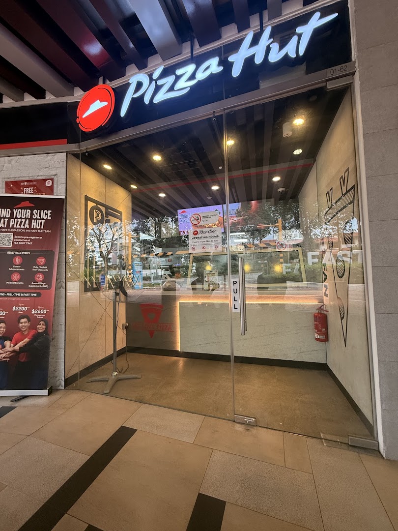 The inviting glass entrance of Pizza Hut, showcasing its prominent logo and a welcoming interior.