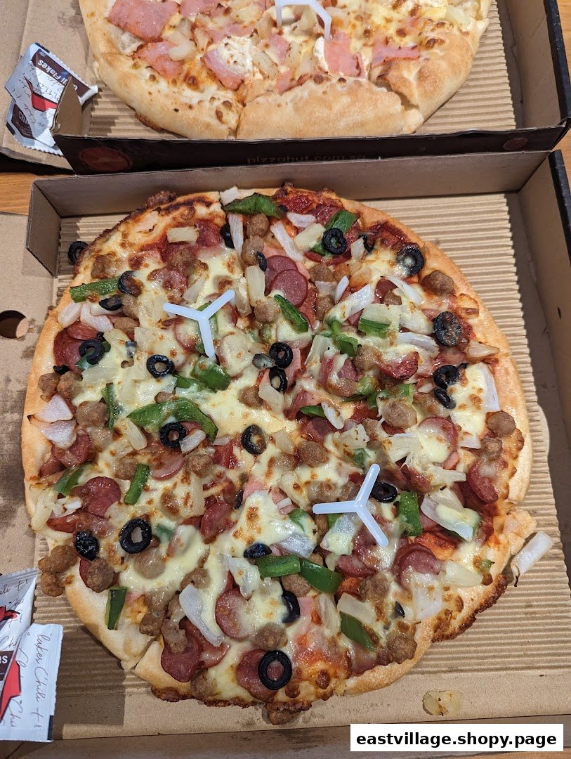 Two delicious pizzas in boxes, one loaded with various toppings, from Pizza Hut.