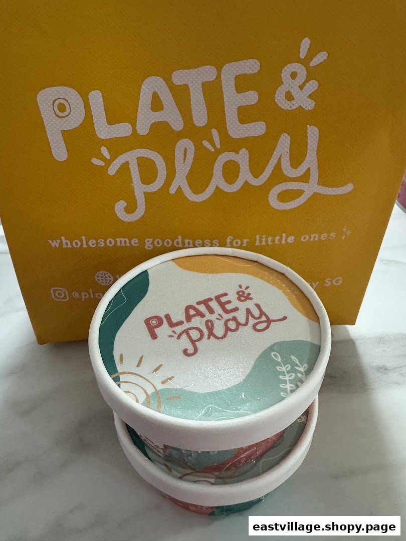 Branded containers and a shopping bag from Plate & Play, featuring wholesome goodness for little ones.