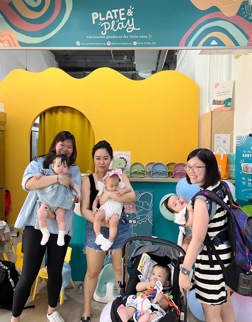 Women and babies enjoying the vibrant interior of Plate & Play, a shop for little ones.