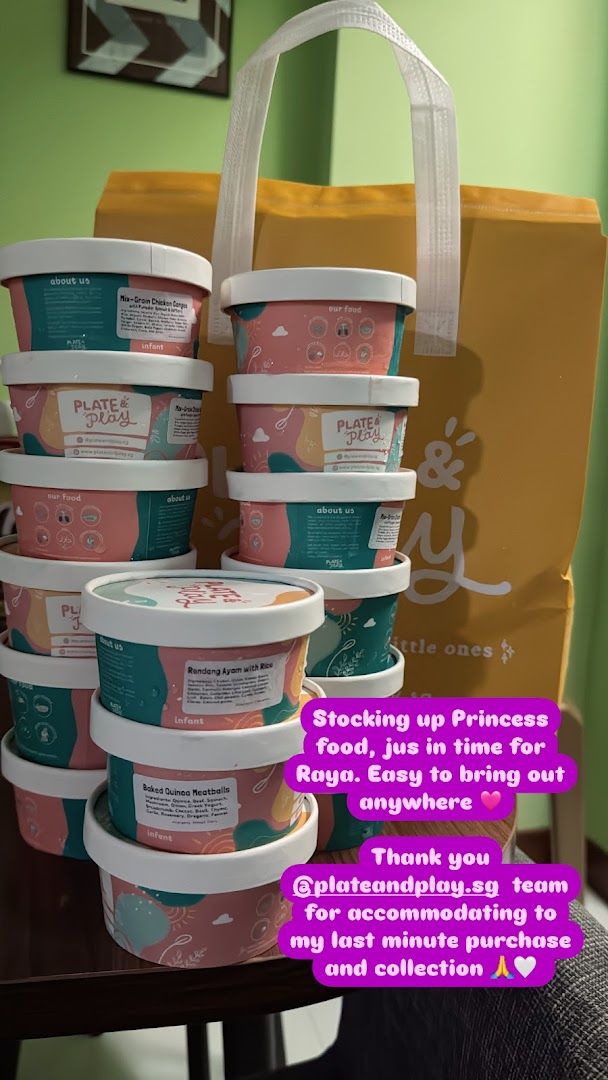 Stacked containers of baby food from Plate & Play next to a branded shopping bag.