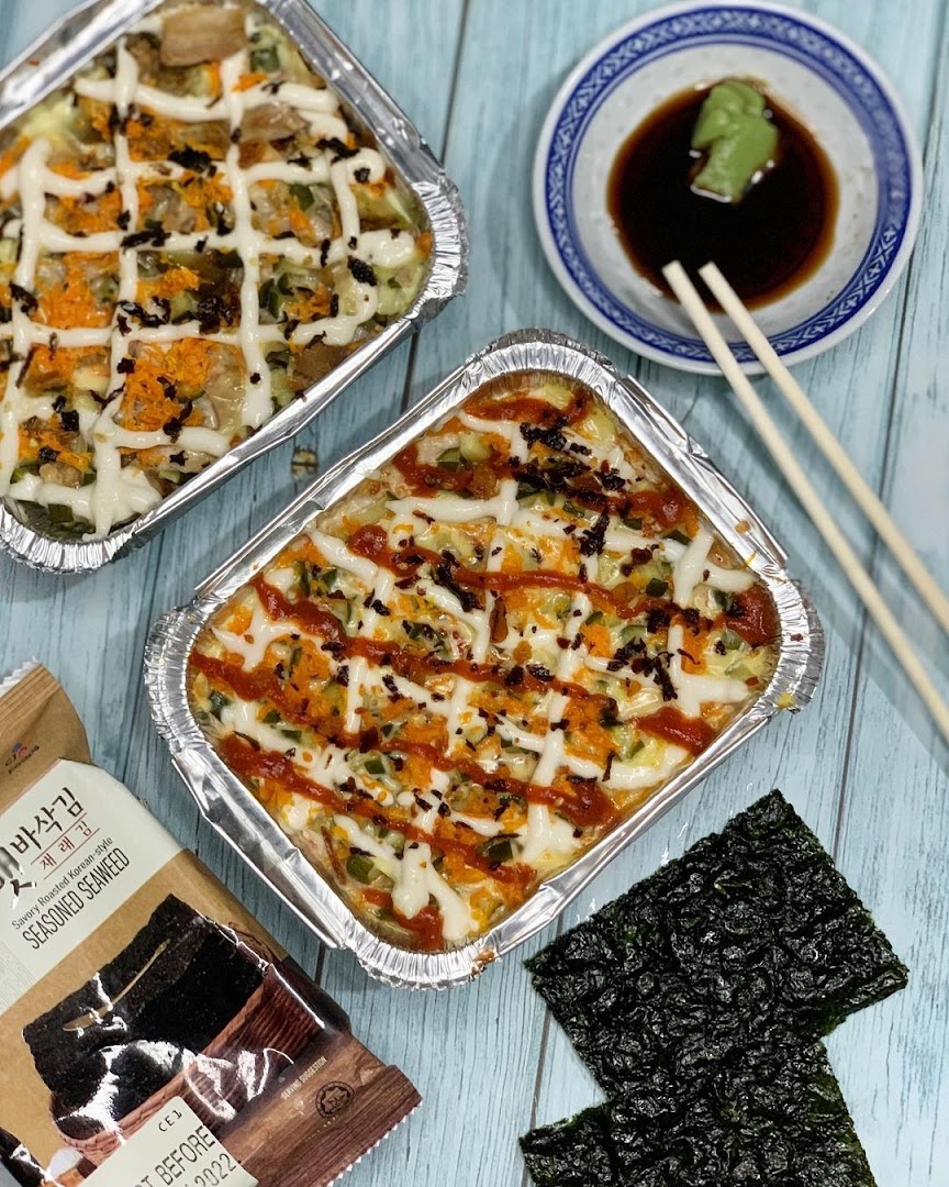 Two foil trays of baked sushi/rice, served with seasoned seaweed, soy sauce, and wasabi.