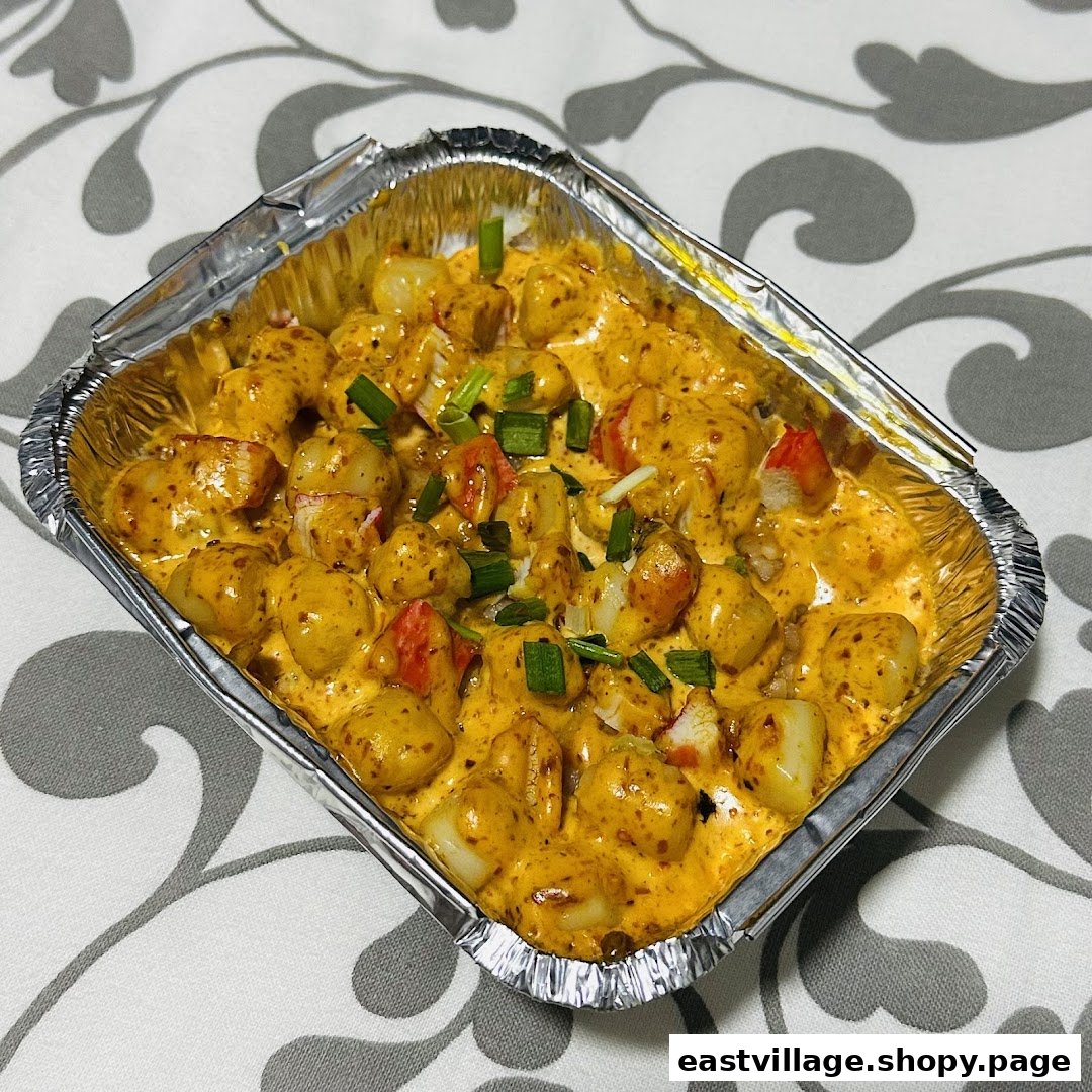 A delicious-looking dish featuring gnocchi or similar pasta in a rich, creamy sauce with crab sticks and green onions.