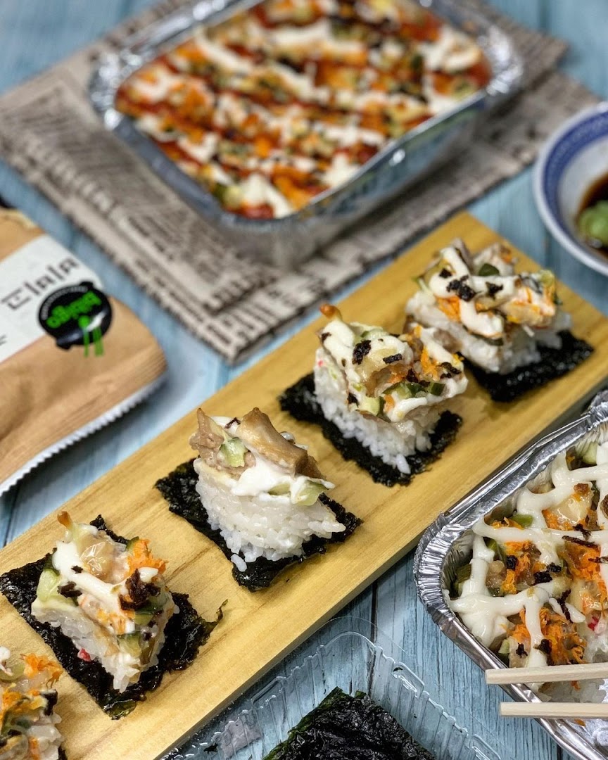 A vibrant display of sushi-style bites and a baked rice dish from RaisuGood.