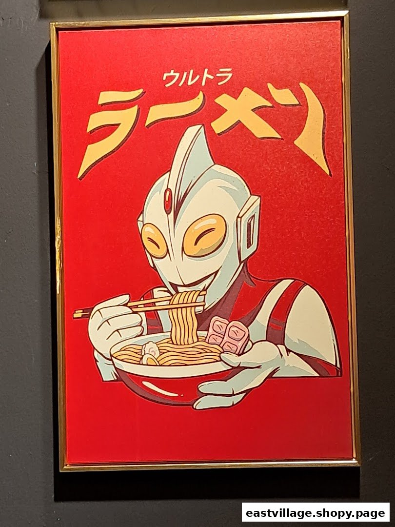 A framed poster featuring an Ultraman-like character happily eating a bowl of ramen noodles.