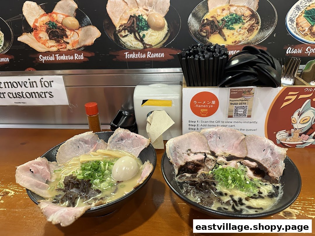 Two delicious bowls of ramen served on a counter, with menu displays and ordering instructions in the background.