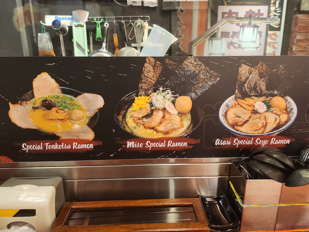 A vibrant display board showcasing three different ramen dishes with their names.