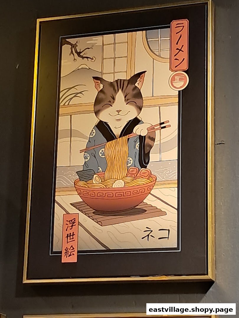 A framed artwork depicting a happy cat in traditional Japanese attire enjoying a bowl of ramen.