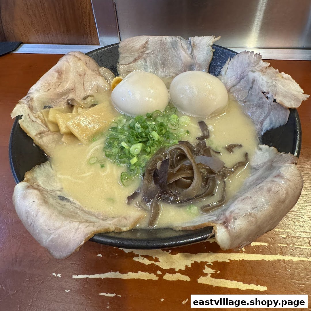 A close-up of a large, inviting bowl of ramen with pork slices, soft-boiled eggs, bamboo shoots, and mushrooms.