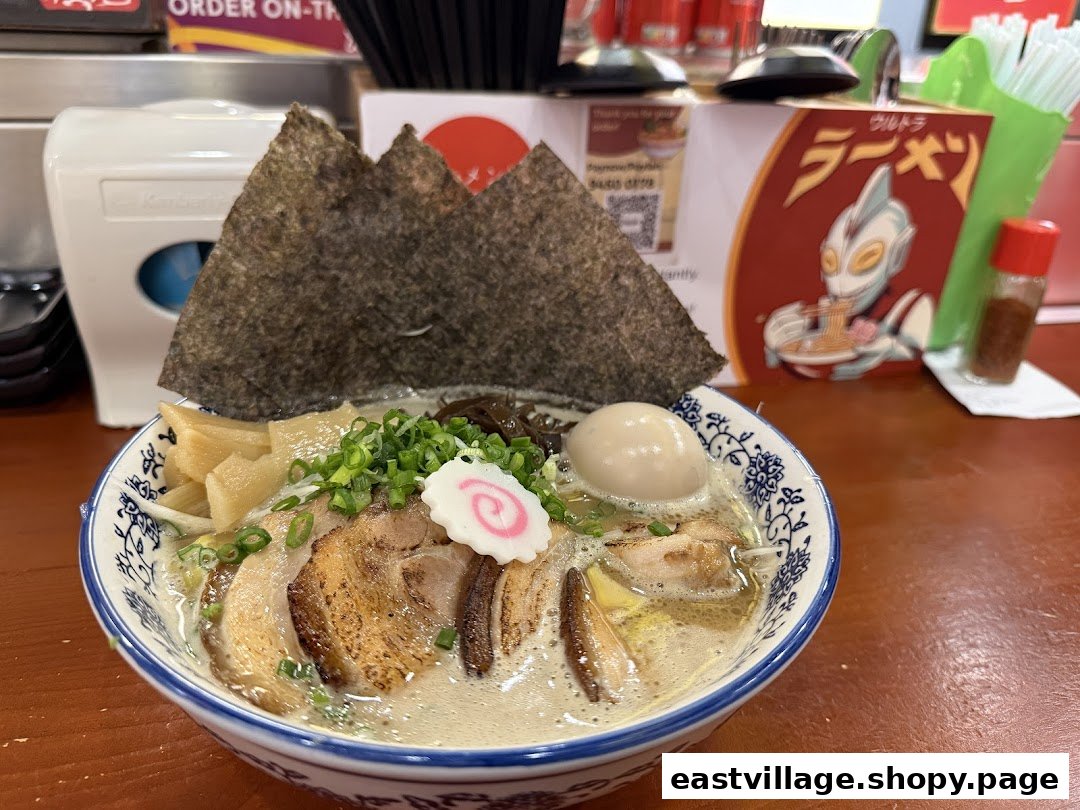 A close-up of a delicious bowl of ramen with chashu pork, egg, seaweed, and other toppings.