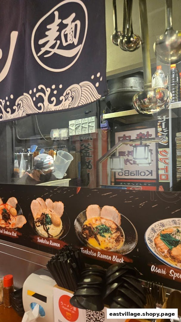 An interior view of Ramen-ya, showcasing delicious ramen dishes on display and a chef at work.