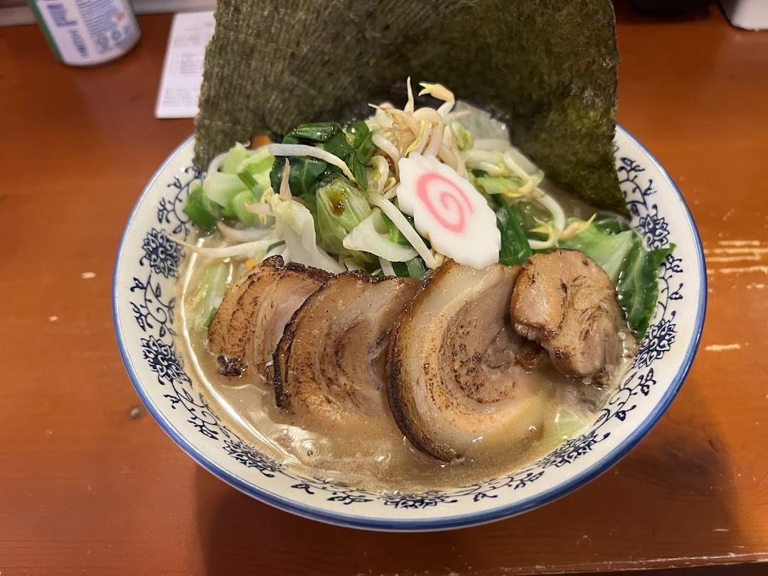 A close-up of a delicious bowl of ramen with pork belly, vegetables, and nori.