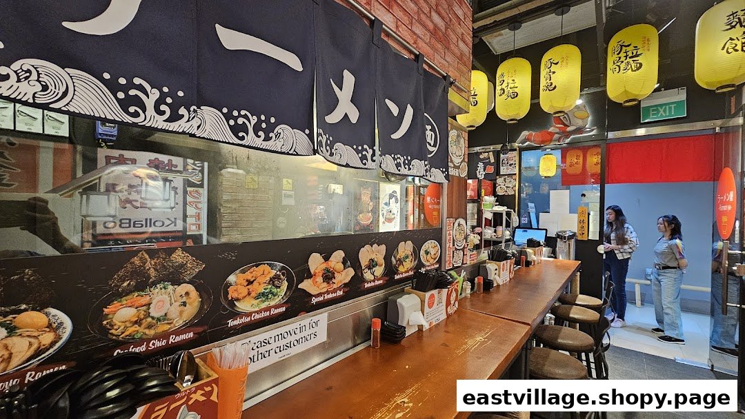 Cozy ramen shop interior with counter seating, kitchen view, and customers.
