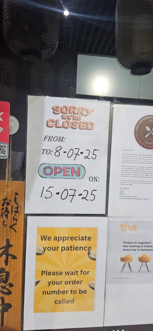 Notices on a Ramen-ya shop front, including temporary closure dates and customer instructions.