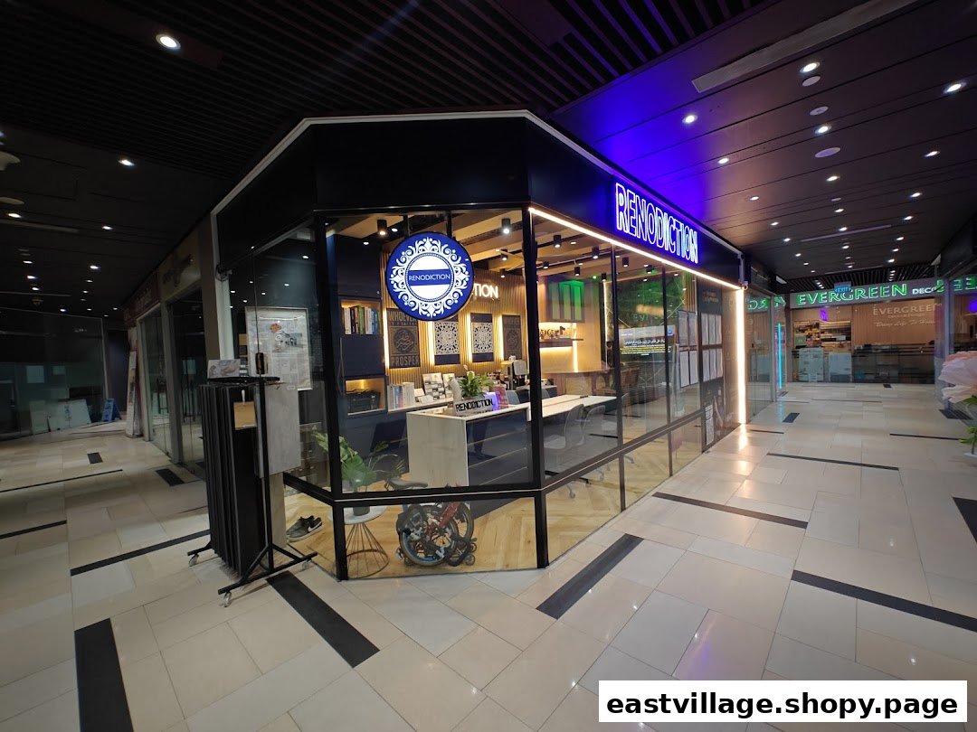 The modern glass-fronted shop RENODICTION PTE. LTD. with a prominent blue neon sign in a mall corridor.
