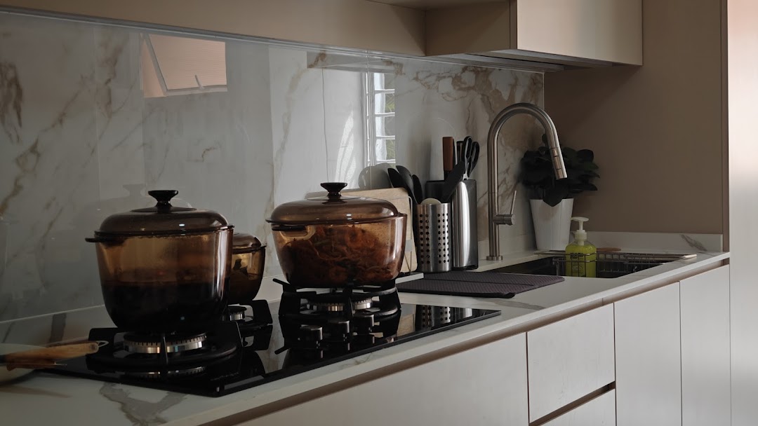 A modern kitchen counter featuring a stove with glass pots, a sink, and kitchen utensils.