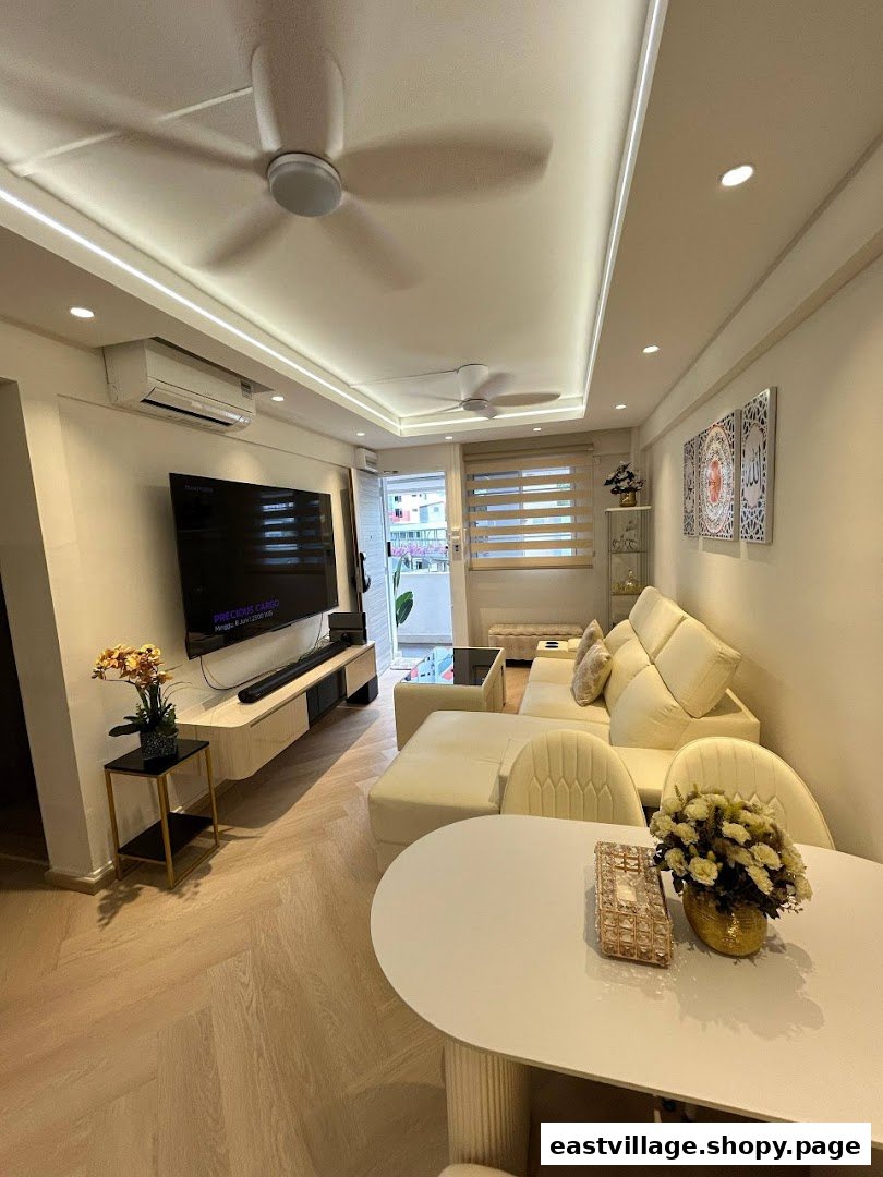A modern, well-lit living room featuring a large sectional sofa, TV console, and dining area with light wood flooring.