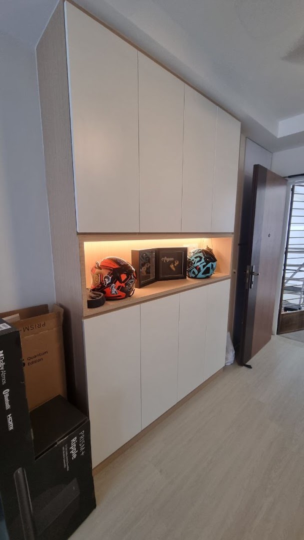 A custom built-in cabinet with an illuminated display shelf featuring helmets and framed items.