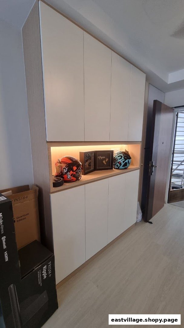 A custom built-in cabinet with an illuminated display shelf featuring helmets and framed items.
