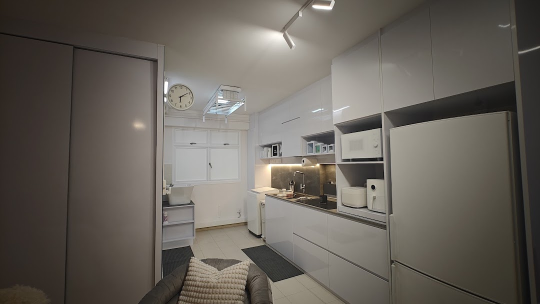 A sleek, modern white kitchen and utility area with integrated appliances and smart storage solutions.