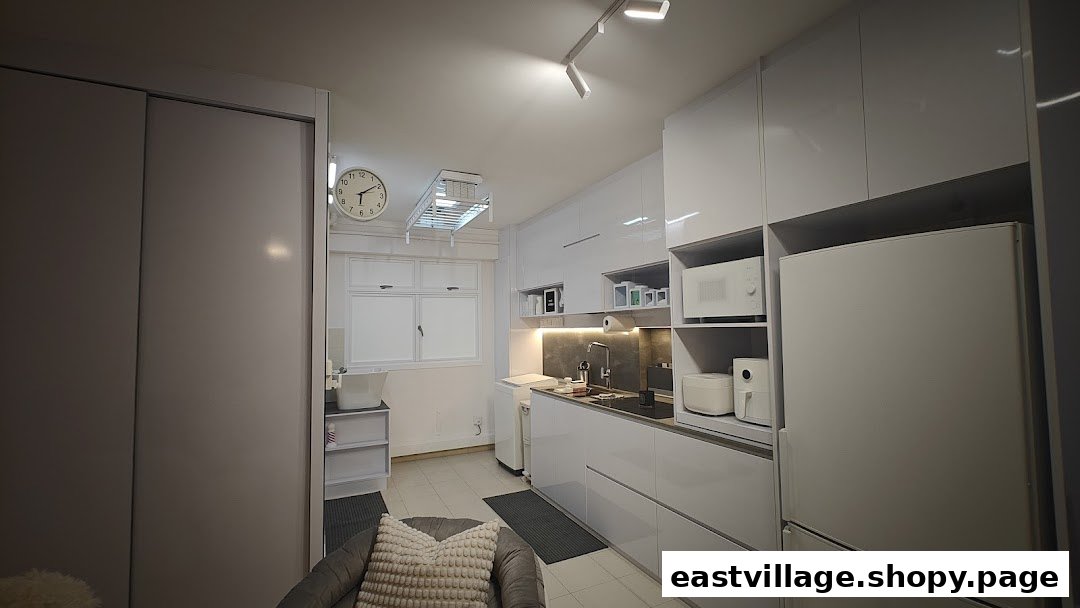 A sleek, modern white kitchen and utility area with integrated appliances and smart storage solutions.