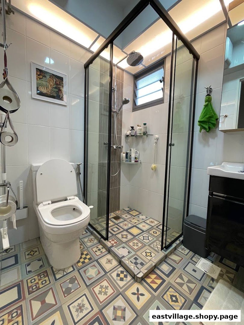 A modern bathroom featuring a sleek glass shower enclosure, a white toilet, and vibrant patterned floor tiles.