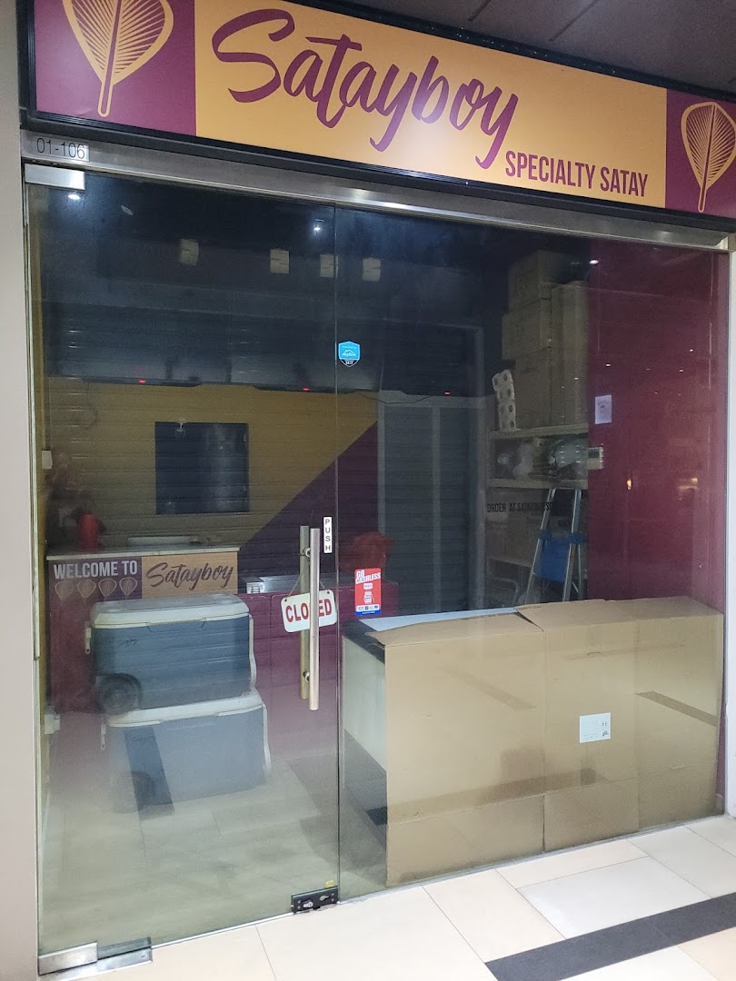 The storefront of Satayboy, a specialty satay shop, featuring its vibrant signage and glass entrance.
