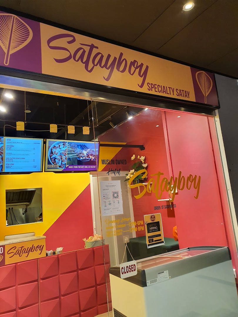 The vibrant red and yellow shopfront of Satayboy, specializing in authentic satay.