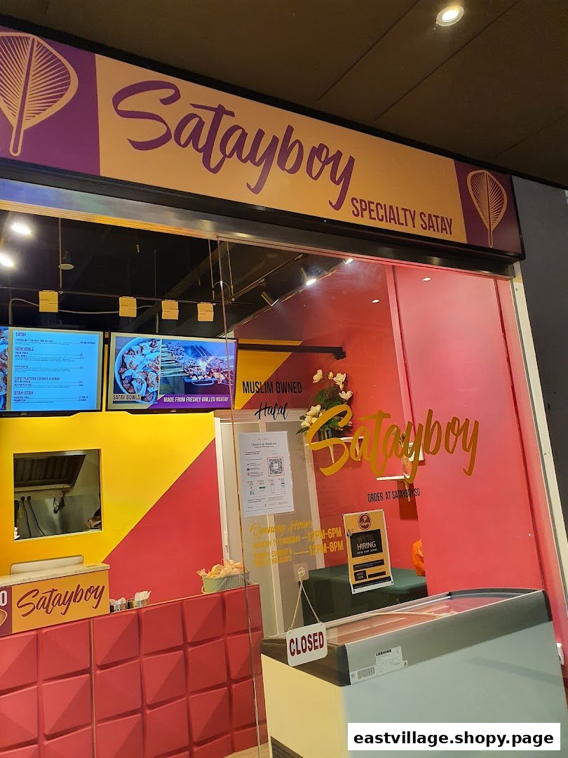 The vibrant red and yellow shopfront of Satayboy, specializing in authentic satay.