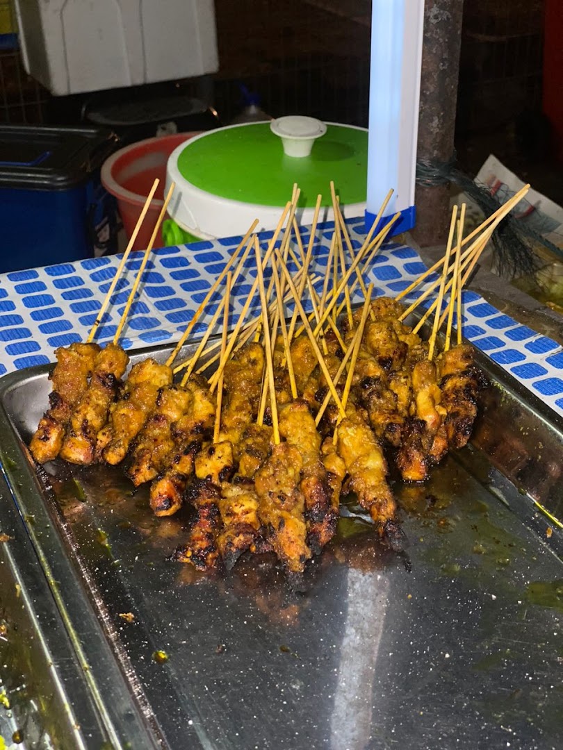 A large tray filled with numerous freshly grilled satay skewers, showcasing the delicious food.