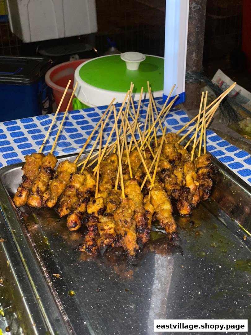 A large tray filled with numerous freshly grilled satay skewers, showcasing the delicious food.