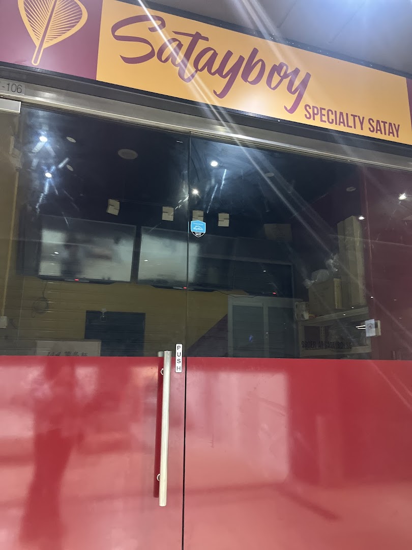 The storefront of Satayboy, featuring its vibrant sign and glass entrance, specializing in satay.