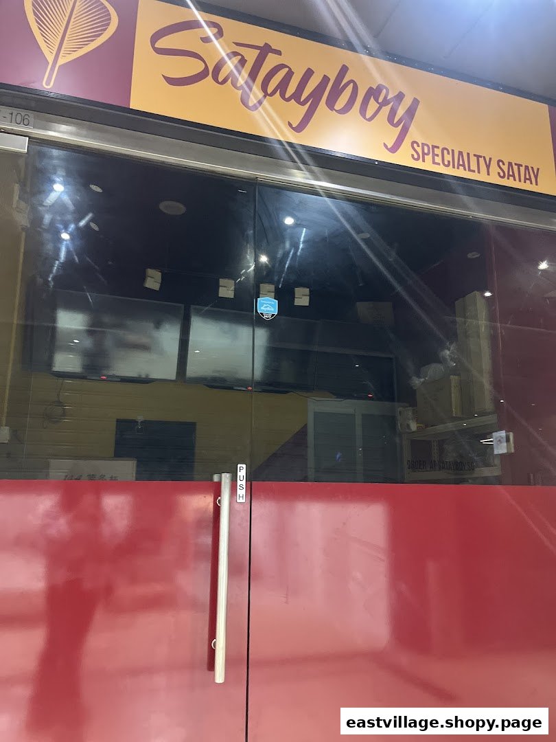 The storefront of Satayboy, featuring its vibrant sign and glass entrance, specializing in satay.