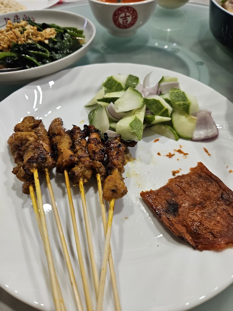 A plate of delicious satay skewers with fresh cucumber and onion, ready to be enjoyed.