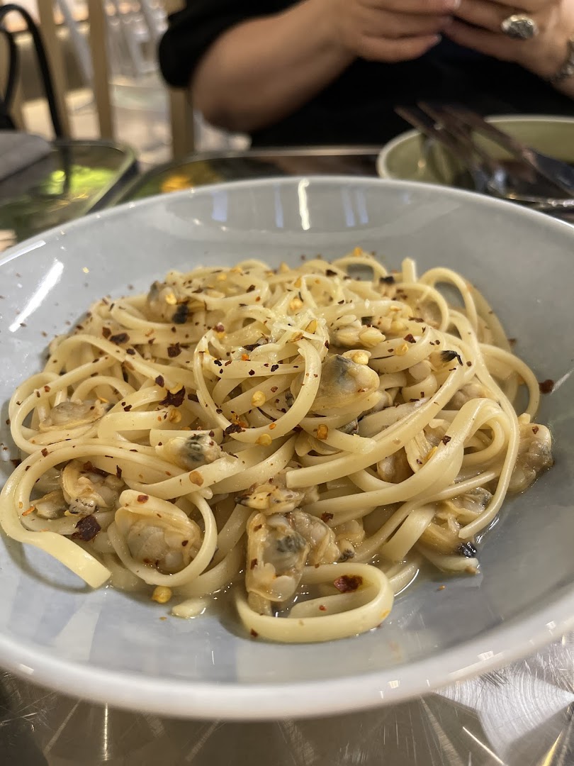 A close-up of a delicious bowl of linguine pasta with clams and chili flakes.