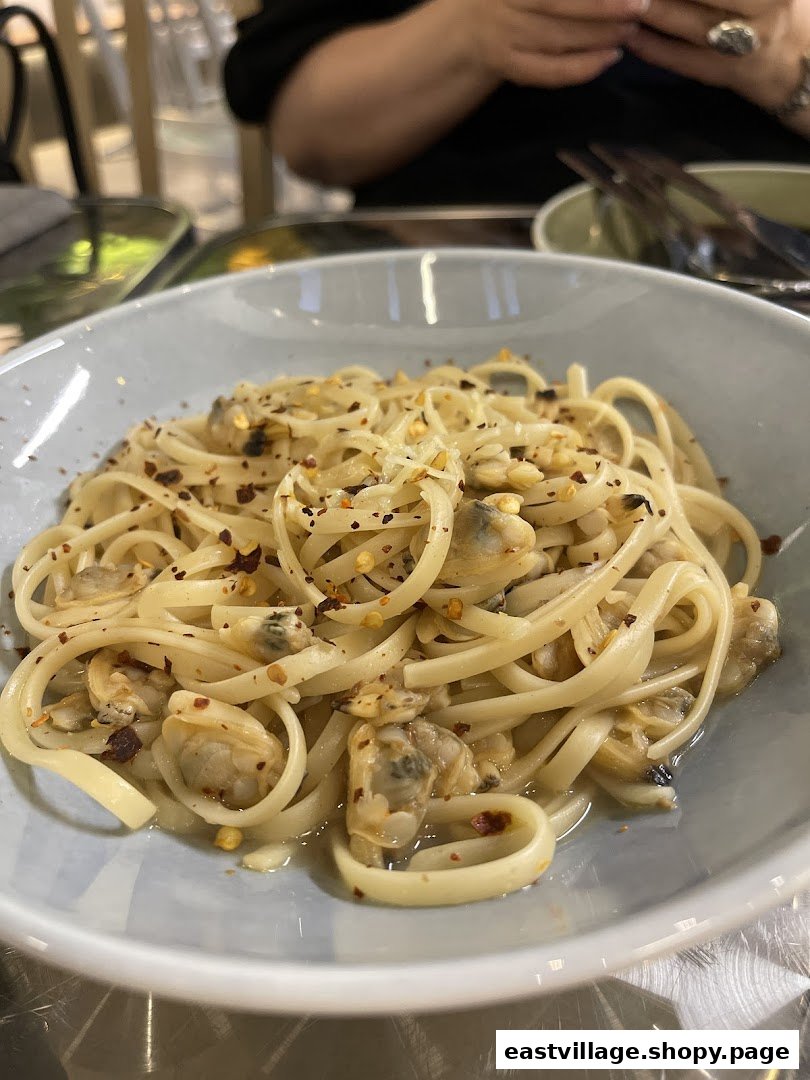 A close-up of a delicious bowl of linguine pasta with clams and chili flakes.