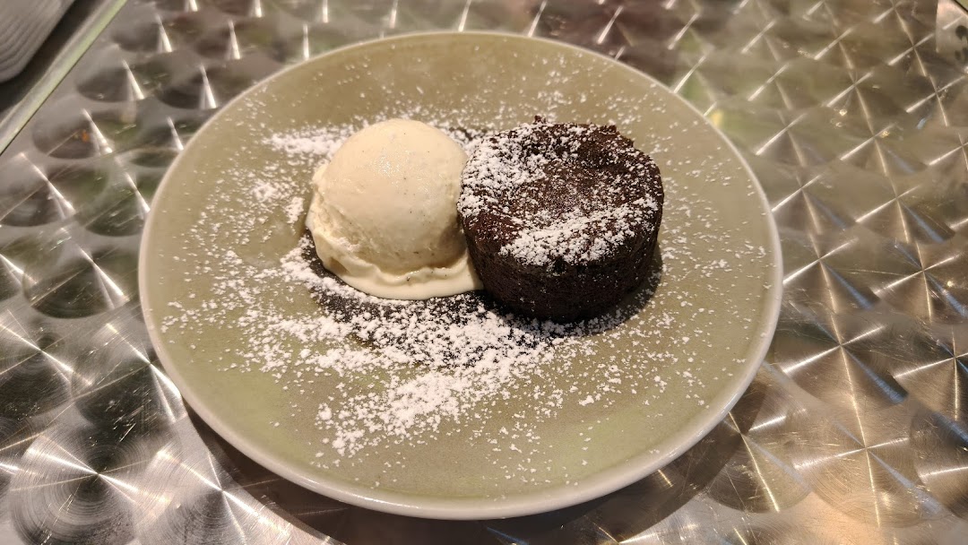 A delicious chocolate lava cake with a scoop of vanilla ice cream, dusted with powdered sugar.