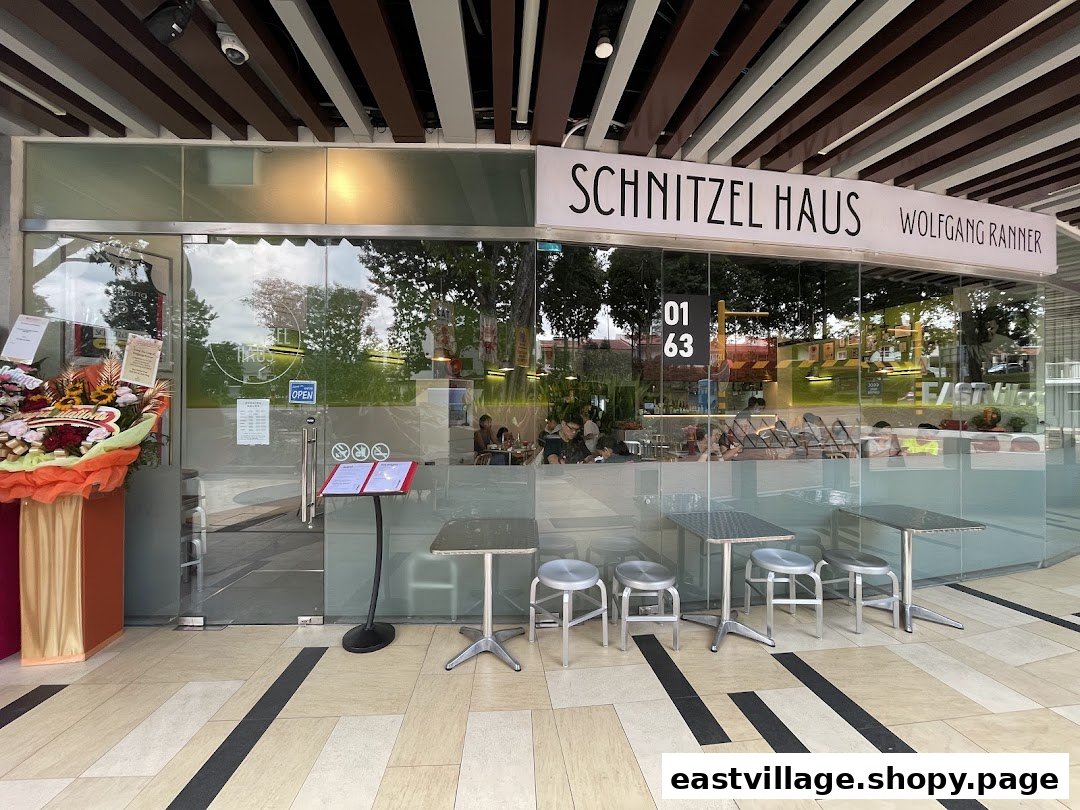 Exterior view of Schnitzel Haus Wolfgang Ranner, showcasing its glass facade and outdoor seating.