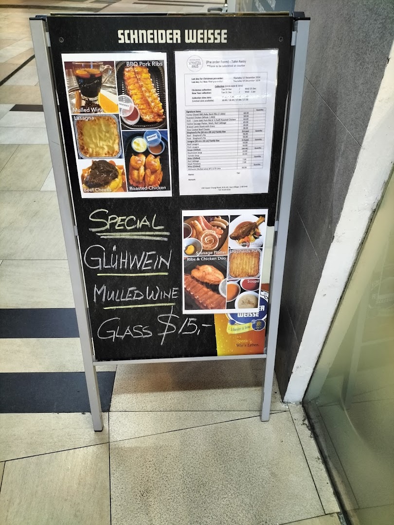 An A-frame sign displaying a menu with German and European dishes, including a mulled wine special.