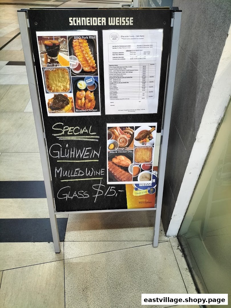 An A-frame sign displaying a menu with German and European dishes, including a mulled wine special.