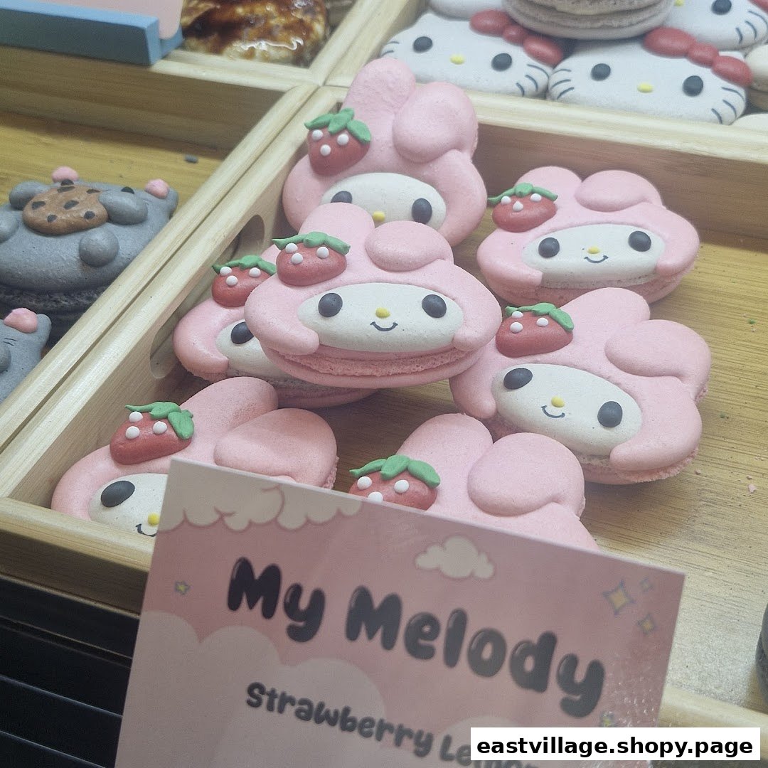 Close-up of adorable pink My Melody character macarons with strawberry decorations in a display case.