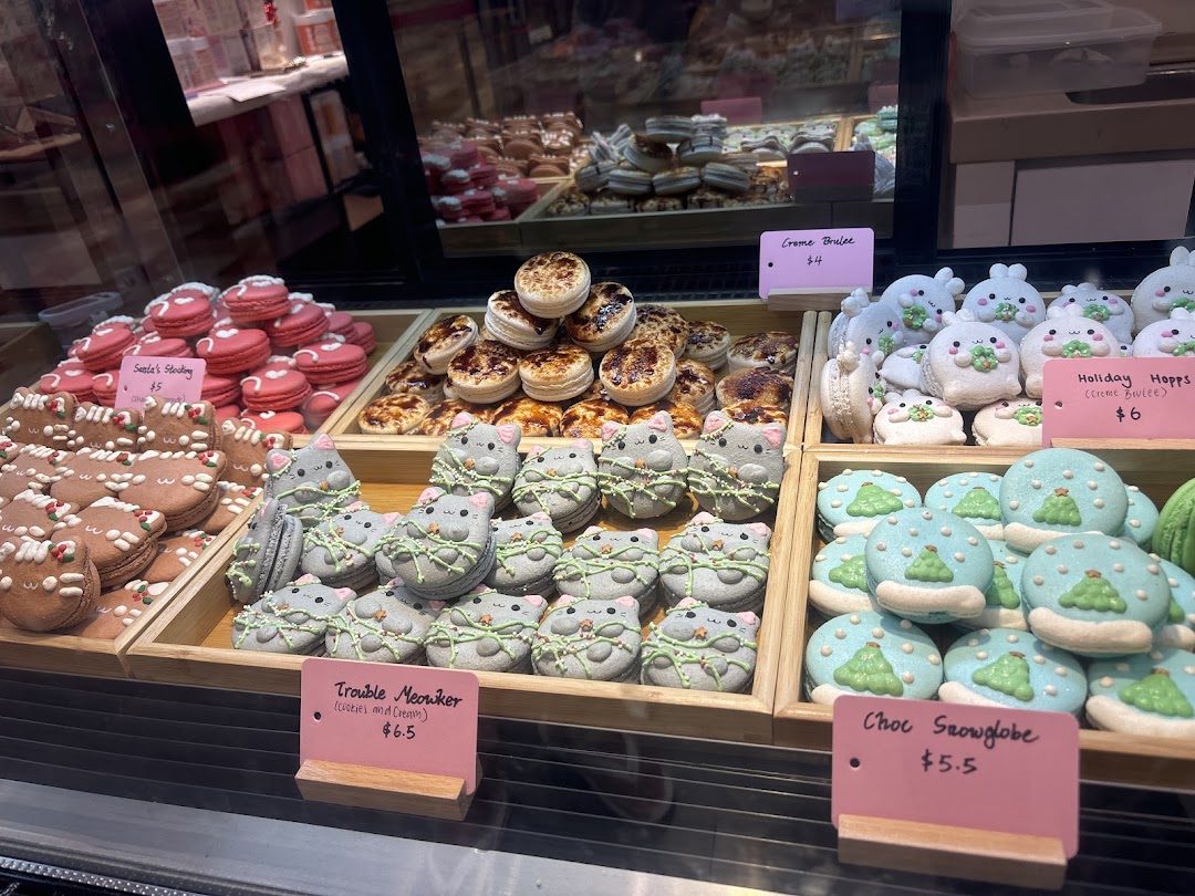 A vibrant display of festive macarons and tarts, including character and holiday themes, at Sugarsmith.